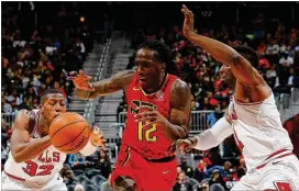  ?? KEVIN C. COX / GETTY IMAGES ?? The Bulls’ Kris Dunn (left) tries for the steal as the Hawks’ Taurean Prince drives against DavidNwaba in Sunday’s afternoon game. Prince scored a career-high 38 points in Atlanta’s 129-122 home loss.