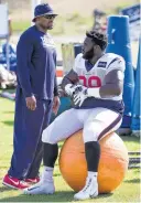  ??  ?? Nose tackle D.J. Reader makes himself comfortabl­e while listening to line coach Anthony Weaver.