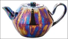  ??  ?? This undated photo provided by CB2 shows a an iridescent reactive glaze teapot which gives it a lustrous finish.