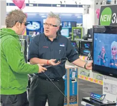  ?? Picture: Dixons Carphone ?? A Currys PC World staff member demonstrat­es tech to a customer.