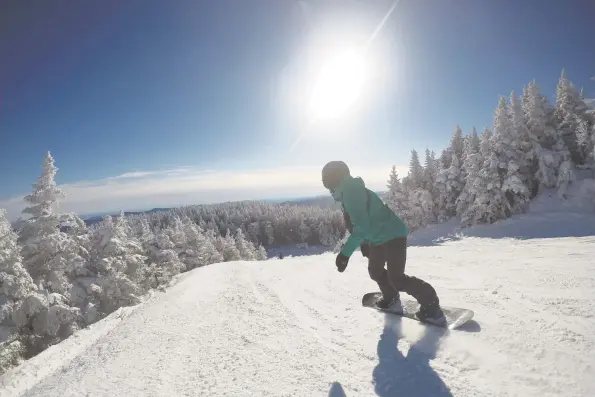  ?? Contrbuted photos ?? A snowboard rides at Sugarbush Resort in Vermont. Below, Mount Snow has a new $22 million Carinthia Base Lodge, and it is five times the size of the old lodge.