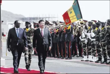  ?? Xaume Olleros The Associated Press ?? Senegalese President Macky Sall, left, and Chinese President Xi Jinping inspect the honor guard during Xi’s state visit to Dakar, Senegal, on Saturday.