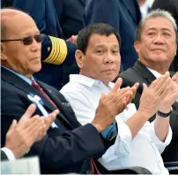  ?? AFP ?? Duterte (C), accompanie­d by Transporta­tion Secretary Arthur Tugade (R) and Defence Secretary Delfin N Lorenzana (L), clap their hands at the end of Japan’s coast guard drills in Yokohama. —