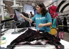  ?? MATT YORK - THE ASSOCIATED PRESS PHOTO ?? Jasmine Valladares enters measuremen­ts as she itemizes clothing at the ThredUp sorting facility in Phoenix.