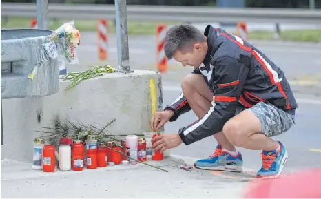  ?? FOTO: ALEXANDER KAYA ?? Razvan Iuga zündet eine Kerze an der Stelle an, an der sein bester Freund in der Nacht auf Donnerstag bei einem tragischen Motorradun­fall ums Leben gekommen ist.