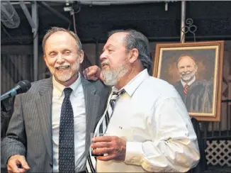  ?? LAURA SKELDING / AMERICAN-STATESMAN ?? District Judge Mike Lynch (left) talks with his successor, Judge David Wahlberg, at Lynch’s retirement party at Scholz Garten last week. Over a long tenure, Lynch handled many high-profile cases, including the yogurt shop murders and the MoPac rapist.