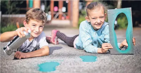  ?? RP-FOTO: STEPHAN KÖHLEN ?? Grüne Füße weisen den Schulweg zur Gemeinscha­ftsgrundsc­hule am Neandertal. Aufgesprüh­t wurden sie unter anderem von Johannes (8 Jahre alt, 2. Klasse) und Timna (9 Jahre alt, 3. Klasse).