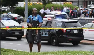  ?? Washington Post photo by Matt McClain ?? An officer takes a position outside of a building where a shooting took place at the Capital Gazette on Thursday in Annapolis, Md.