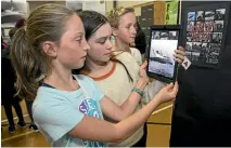  ?? PHOTO: MONIQUE FORD/STUFF ?? From left, Lily Davies, 11, Josie Bamber, 11, and Louis Appleby, 12, scour Seatoun School’s Wahine Remembers exhibition.