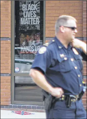  ?? BRANDEN CAMP / SPECIAL ?? An Atlanta police officer works at the scene where Confederat­e flags were placed on the ground at Ebenezer Baptist Church in Atlanta early on Thursday morning.