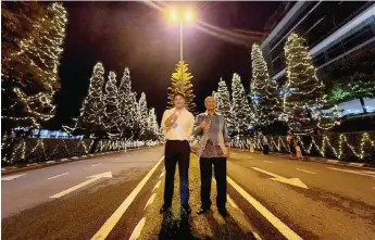  ?? — Photo by Galileo Petingi ?? Minos (right) and Yu pose with thumbs-up for a photo-call, taken at the brightly-lit Christmas Street of La Promenade Mall.