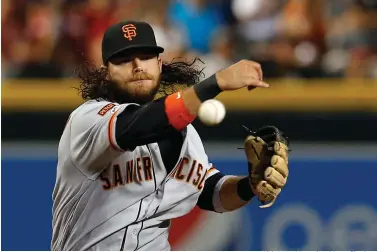  ?? Rick Scuteri/Associated Press file photo ?? ■ San Francisco Giants shortstop Brandon Crawford throws in the first inning on Aug. 17, 2019, during a baseball game against the Arizona Diamondbac­ks in Phoenix. Finally, major leaguers are on track to resume this virus-abbreviate­d 2020 season. The hiatus has provided a welcomed dose of extra family time for many, but the unpreceden­ted idling this spring and summer for players used to being on the diamond daily has predictabl­y created a collective antsy feeling around the game.