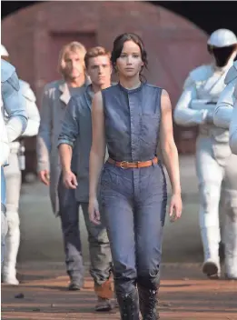  ?? PHOTOS BY MURRAY CLOSE/LIONSGATE ?? Katniss, played by Jennifer Lawrence, is surrounded by peacekeepe­rs in “The Hunger Games: Catching Fire.”