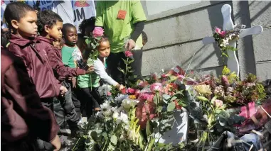  ?? PICTURE: ARMAND HOUGH/AFRICAN NEWS AGENCY(ANA) ?? TRAUMATIC MOMENT: Children place flowers at the site where the body of Courtney Pieters was found in a shallow grave in May last year. She was raped and murdered. Community Safety MEC Dan Plato, children and community members from Eerste River visited...