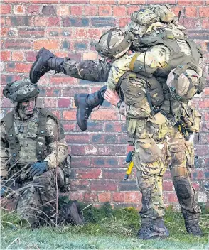  ??  ?? Royal Marines taking part in a raid at Dalbeattie in Scotland during the