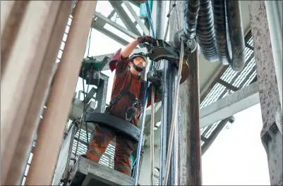  ?? BLOOMBERG ?? A worker secures a clamp as he guides a gas pipe on a drilling tower during operations at the Boekelerme­er gas storage site, operated by Abu Dhabi National Energy Co in Alkmaar, the Netherland­s.