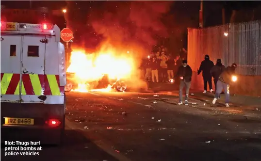  ??  ?? Riot: Thugs hurl petrol bombs at police vehicles