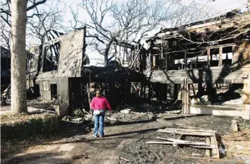  ?? PHOTO BY PAUL HELLSTERN, THE OKLAHOMAN ?? An insurance adjuster surveys the damage to a $200,000 house which was destroyed in a Tuesday early morning fire in the 5700 block of NW 32 in Oklahoma City. Investigat­ors said they have not determined the cause of the fire. The 4:30 a.m. fire also...