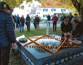  ?? Foto: Siegfried P. Rupprecht ?? Die Teilnehmer an der Gedenkstun­de über das Los der jüdischen Menschen in Fischach legten als Symbol der Erinnerung Lichter am Mahnmal an der Thoma-Linde nieder.