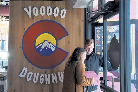  ?? Hyoung Chang, The Denver Post file ?? Logan Bagby, right, and Madi Gourley, bought the box of doughnuts at Voodoo Doughnut on South Broadway in 2019.