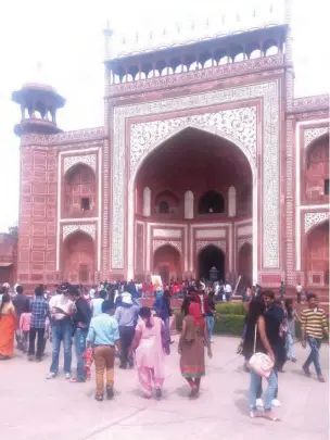  ??  ?? Tourists walk towards a building inside the Taj Mahal