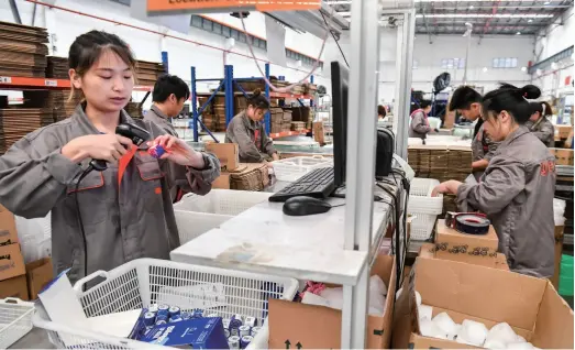  ??  ?? Workers prepare products for delivery at the warehouse