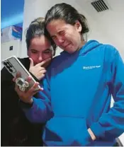  ?? LAVANDIER/AP MARTA ?? Melanie Rolo Gonzalez, right, and her sister Merlyn hold a video call with their mother and grandfathe­r back home in Cuba, from the home of a family friend in Daytona on Jan. 3.
