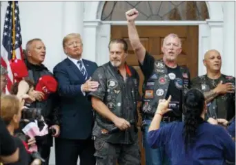  ?? CAROLYN KASTER — THE ASSOCIATED PRESS ?? President Donald Trump stands in the rain with members of Bikers for Trump and supporters after saying the Pledge of Allegiance, Saturday at the clubhouse of Trump National Golf Club in Bedminster, N.J.