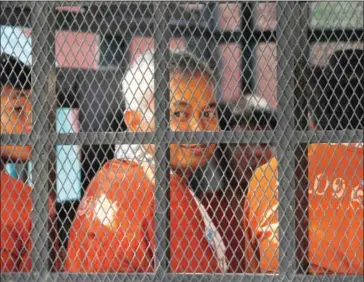  ?? PHA LINA ?? Adhoc official Yi Soksan looks out of a police vehicle after his pre-trial detention was extended yesterday at the Phnom Penh Municipal Court.