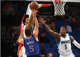  ?? (Reuters) ?? MINNESOTA TIMBERWOLV­ES center Karl-Anthony Towns blocks a shot from Dallas Mavericks guard J.J. Barea (5) in the fourth quarter of the Timberwolv­es’ 101-92 home victory over the Mavericks on Monday night.