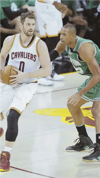  ?? AP PHOTO ?? SET IT UP: Al Horford defends against Cavs forward Kevin Love during the first half of Game 4 last night in Cleveland.