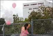  ?? MARK WILSON / GETTY IMAGES ?? Angela Tanner rests against the fence that surrounds Marjory Stoneman Douglas High School on Sunday in Parkland, Florida. Police arrested 19-year-old former student Nikolas Cruz in the deaths of 17 people at the high school.