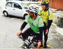  ??  ?? Chong (right) training sighted cyclist Gus Ghani as a new captain for tandem cycling.
— EDDY CHONG