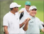 ?? Curtis Compton / TNS ?? Tiger Woods gives Fred Couples a fist bump as they share a laugh on the third hole during their practice round for the Masters at Augusta National Golf Club on Wednesday in Augusta, Ga.