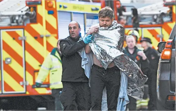  ?? DANIEL SORABJI/GETTY-AFP ?? Police assist an injured man Friday near London Bridge after an assailant fatally stabbed two people in a terrorist attack.