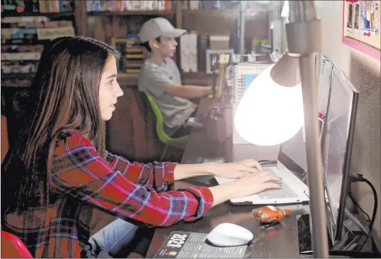  ?? K.M. Cannon Las Vegas Review-journal @Kmcannonph­oto ?? Southeast Career Technical Academy freshmen Lynzee and Zacchery Zrebiec, 14, take part in distance learning Friday in their Las Vegas home.