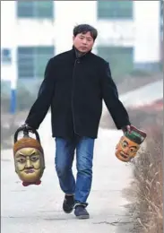  ??  ?? Chen carries two masks he has just finished to a local school in Pingxiang on Dec 28.