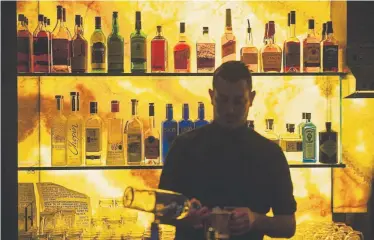  ?? Daniel Brenner, Special to The Denver Post ?? Bartender Daryl Belanger pours drinks during pub trivia Tuesday at Country Club Towers II and III Tavern Bar. The Denver bar is one of the ways area apartment complexes are looking to attract millennial residents.