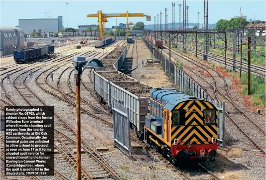  ?? STEVE STUBBS ?? Rarely photograph­ed is shunter No. 08703, which seldom strays from the former Willesden Euro terminal where it works shunting spoil wagons from the nearby
HS2 earthworks at Old Oak Common. Occasional­ly the terminal gates are unlocked to allow a shunt to proceed, as seen on June 17 as it forms a loaded spoil service for onward transit to the former Barrington Cement Works (Cambridges­hire), where the spoil is used to fill in the disused pits.