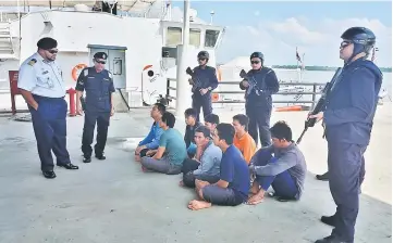  ??  ?? Shahref (left) looking at the Vietnamese crew who were arrested.