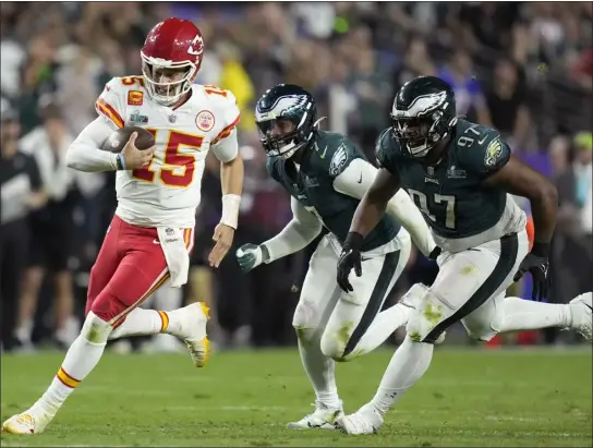  ?? ASHLEY LANDIS — THE ASSOCIATED PRESS ?? Chiefs quarterbac­k Patrick Mahomes, left, runs against the Eagles defense during the Super Bowl on Sunday at State Farm Stadium in Glendale, Ariz.