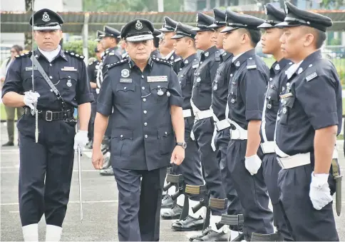  ??  ?? Mazlan inspects the guard-of-honour at the start of the parade.