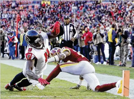  ?? JOE ROBBINS / GETTY IMAGES ?? Julio Jones of the Falcons drags Ha Ha Clinton-Dix of the Redskins toward the end zone as he dives in for a 35-yard touchdown in the fourth quarter at FedEx Field. Jones had gone 12 regular-season games without catching a touchdown pass.