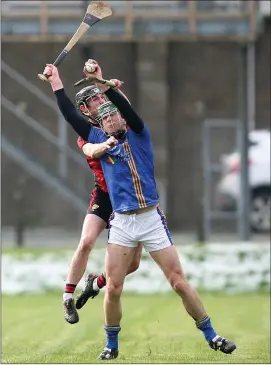  ??  ?? Wicklow’s Eamonn Kearns plucks this ball from the heavens while under pressure from Down’s Paul Sheehan. Photo: Joe Byrne