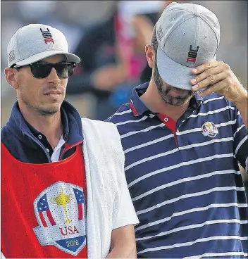  ?? AP PHOTO ?? Dustin Johnson of the U.S. covers his face with the peak of his cap during a foursome match again Europe’s Henrik Stenson and Justin Rose on the opening day of the 42nd Ryder Cup at Le Golf National in Saint-Quentin-en-Yvelines, outside Paris, France, Friday.