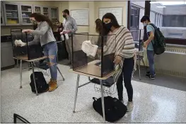  ?? JESSICA HILL — THE ASSOCIATED PRESS FILE ?? Students in teacher Christophe­r Duggan’s science class clean their work areas at the end of class at Windsor Locks High School in Windsor Locks, Conn.