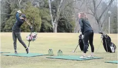  ?? DAVID BEBEE WATERLOO REGION RECORD ?? Faith Hertner, left, and her sister, Ella, hit the driving range March 18 at Cambridge Golf Club, prior to courses being closed due to the coronaviru­s pandemic. The province has given golf courses the green light to open again.