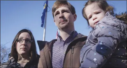  ?? CP PHOTO ?? Edouard Maurice, centre, speaks to reporters outside court while holding his daughter Teal as his wife, Jessica, looks on in Okotoks, Alta., on March 9.