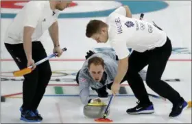  ?? AARON FAVILA —THE ASSOCIATED PRESS ?? Britain’s skip Kyle Smith, center, prepares to throw the stone during their men’s curling match against Sweden at the 2018 Winter Olympics in South Korea on Feb. 16.