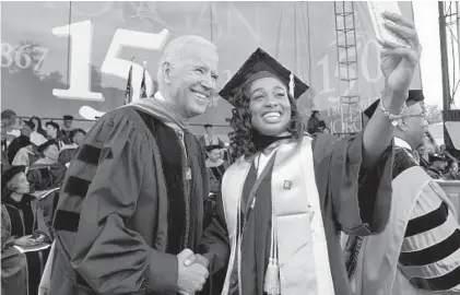  ?? ALGERINA PERNA/BALTIMORE SUN ?? Morgan State University graduate Brittney Gordon, who received her bachelor’s degree in biology, takes a selfie with former Vice President Joe Biden at Morgan State’s commenceme­nt exercises Saturday. Biden urged the graduates to “engage the world...